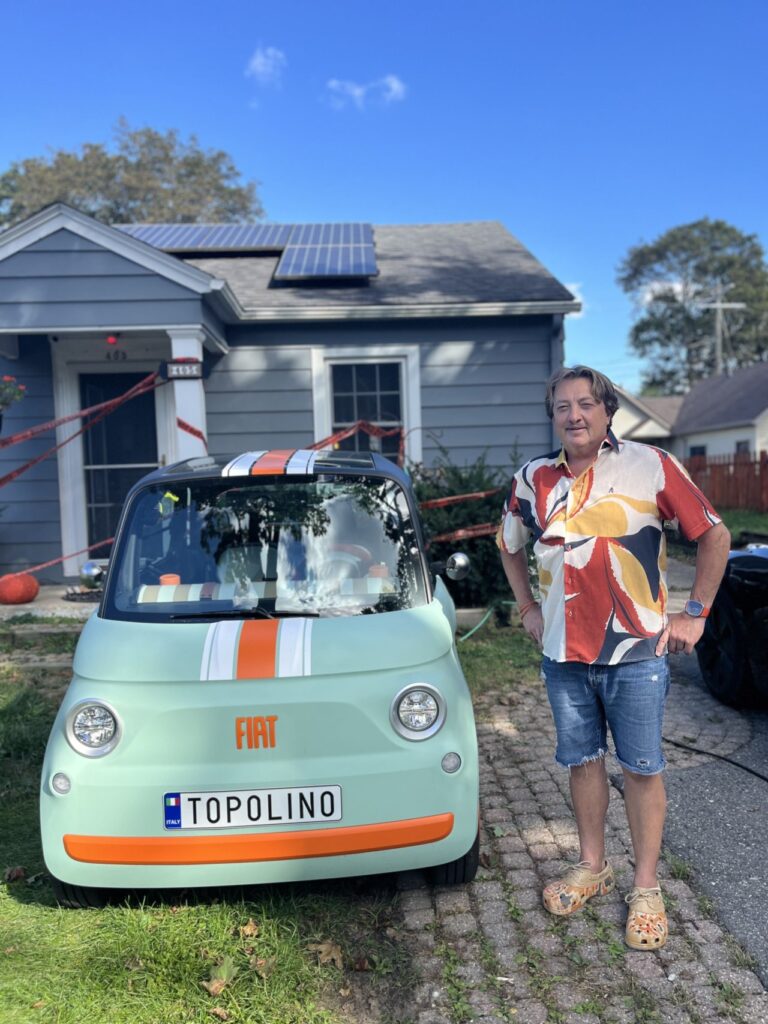 Homem ao lado de carro Fiat.