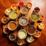 Várias panelas de fondue sobre mesa de madeira