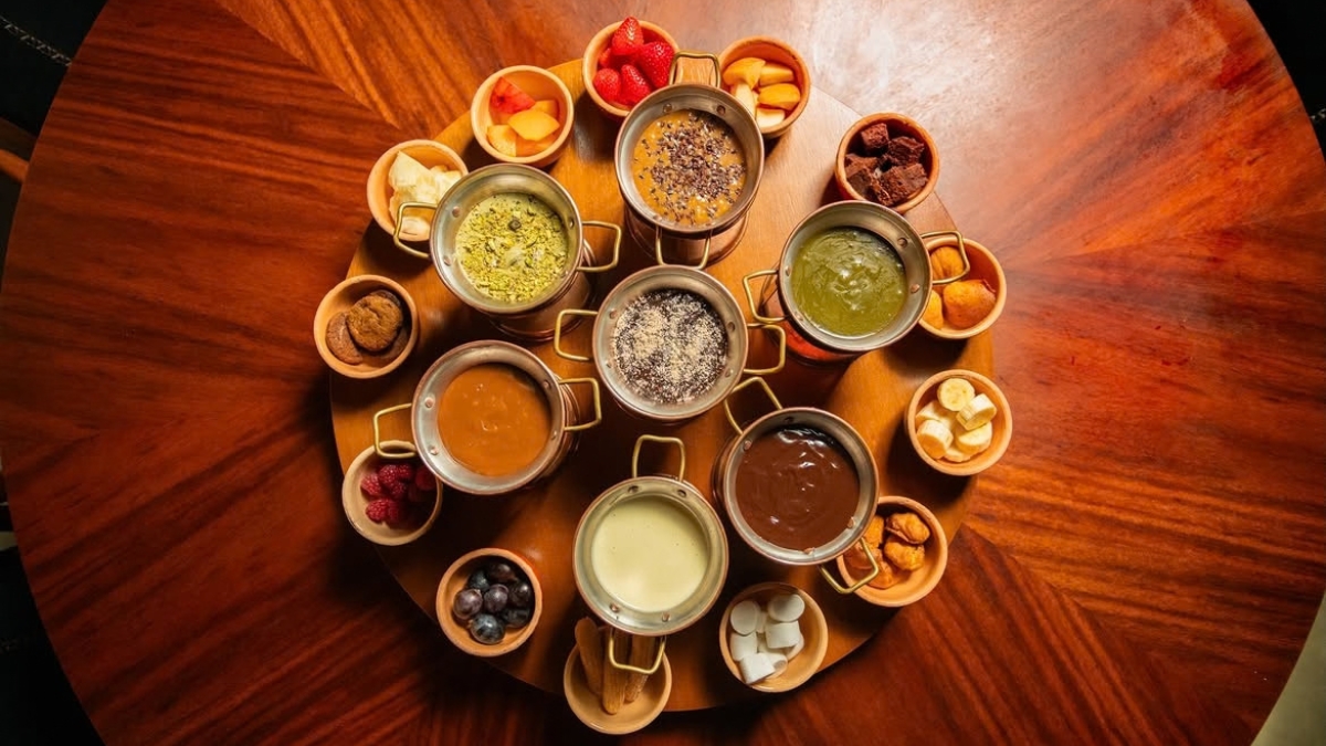 Várias panelas de fondue sobre mesa de madeira