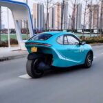Curiositando 10 Um Telufu GT5 azul. O veículo tem três rodas, como um triciclo, mas tem uma cabine fechada, com um design que remete a um carro. O triciclo foi anunciado no mercado a cerca de R$ 22 mil.